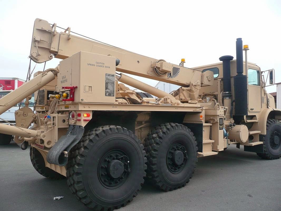 Tan heavy-duty 6x6 military-style wrecker with a rear crane boom, finished in a uniform desert tan